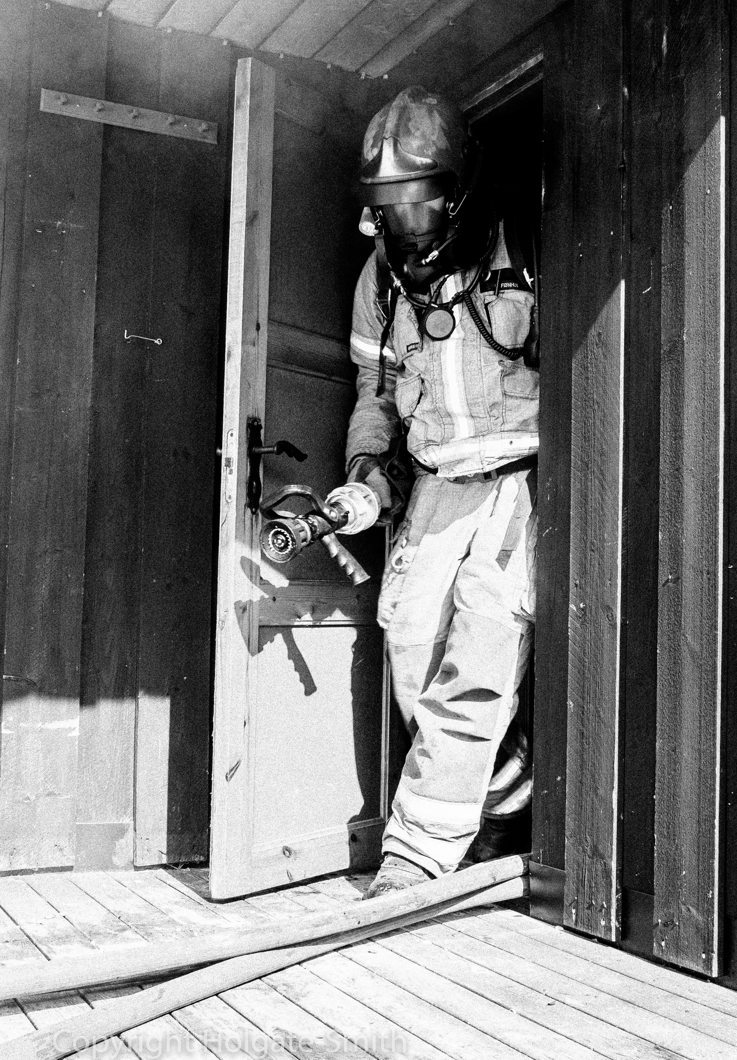 Røykdykker som kommer ut av røykfylt bolig med maske