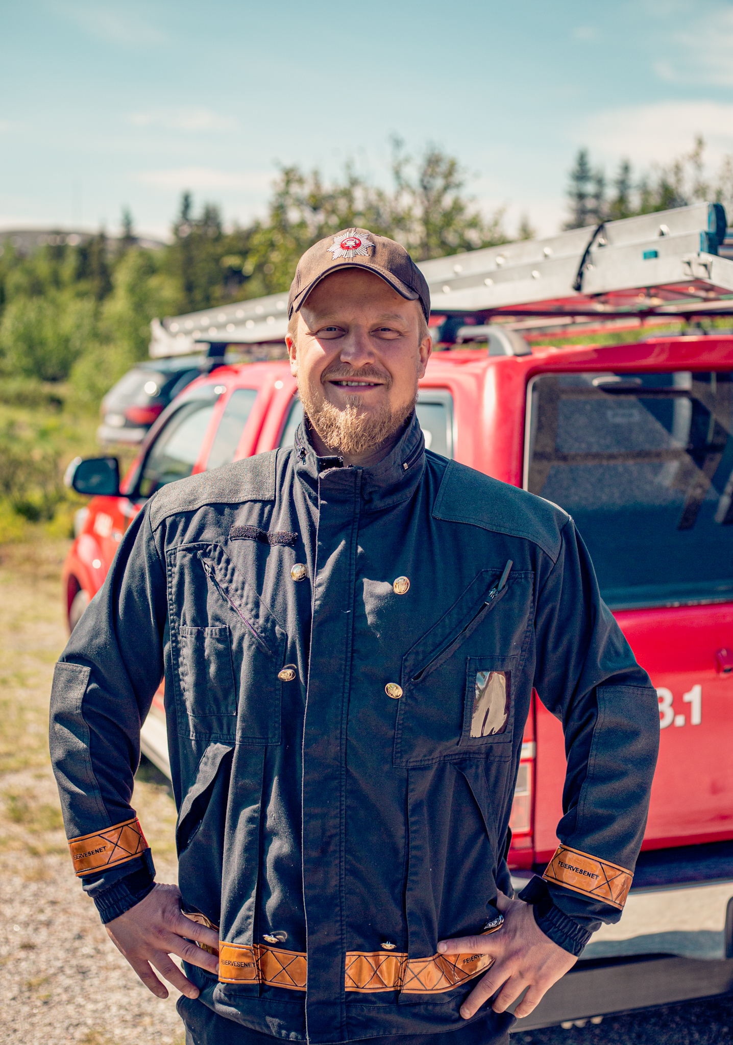 Portrett av feier som står i arbeidsklær fremfor arbeidsbil
